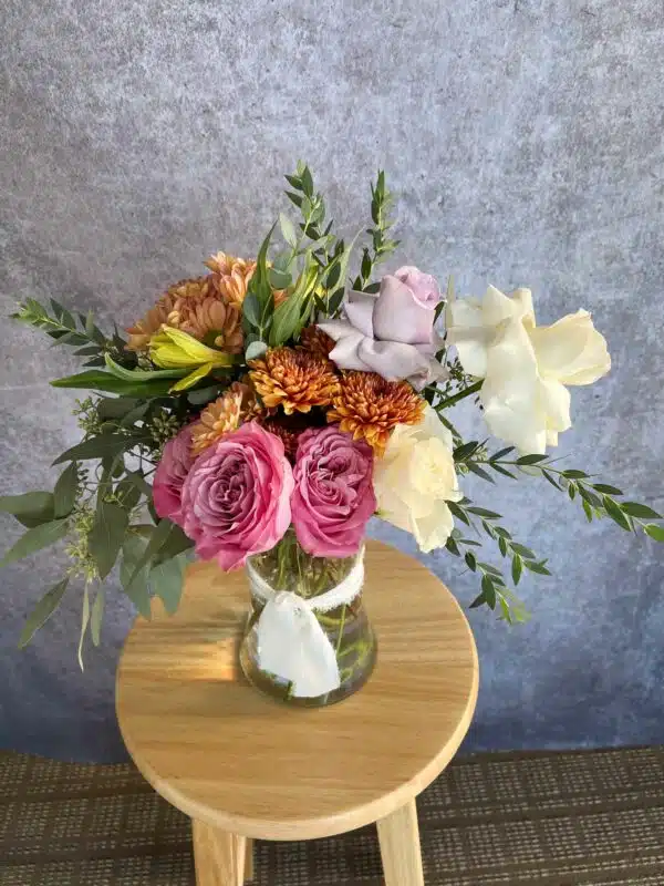 A unique and playful fall flower arrangement with pink and autumn-colored blooms, for sale at our Washington, NC, florist.