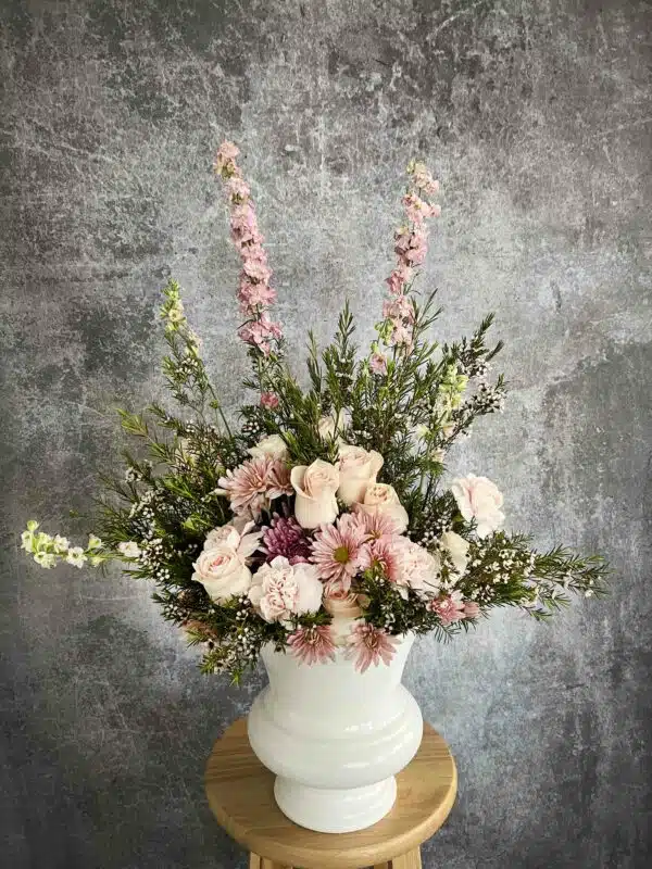 A "Sympathy Pink" flower arrangement featuring pink Garden Roses, Peonies, Snapdragons, Carnations, and Baby's-breath in a white vase, available in Washington, NC.